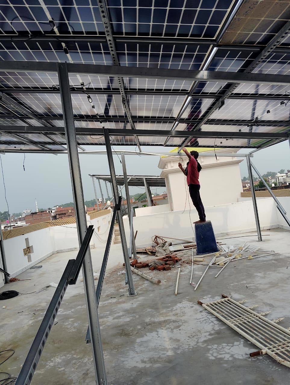 Technician performing electrical wiring beneath a completed solar array