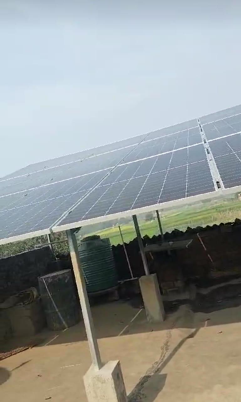 Solar panels installed above a rural farmhouse with surrounding farmland